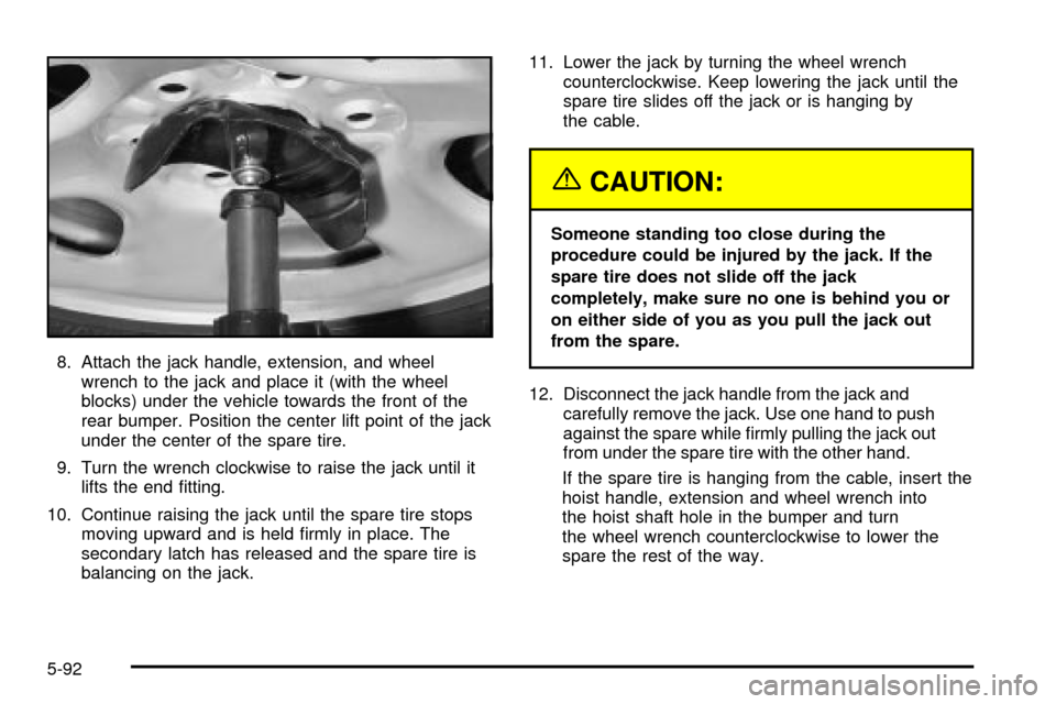 CADILLAC ESCALADE 2003 2.G Owners Manual 8. Attach the jack handle, extension, and wheel
wrench to the jack and place it (with the wheel
blocks) under the vehicle towards the front of the
rear bumper. Position the center lift point of the ja